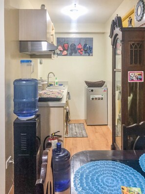 A compact kitchen with a refrigerator, a water dispenser, and a microwave. - Seawind Condominium - Davao City (Davao City)