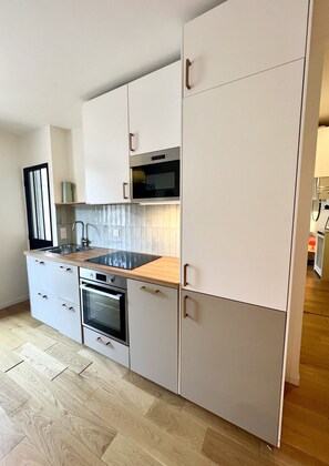 Eine moderne Küche mit eingebautem Ofen, einer Mikrowelle und einem Spülbecken.