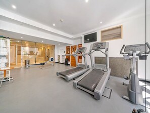 Ein Fitnessstudio mit Laufbändern, einem Ergometer und einer Spiegelwand.