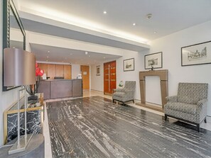 Eine Hotellobby mit Rezeption, Sitzgelegenheiten und Kunstwerken an den Wänden.