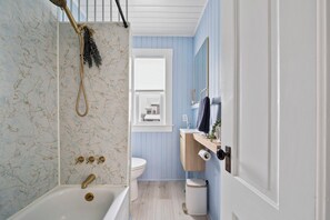 Een badkamer met een bad, toilet en wastafel.