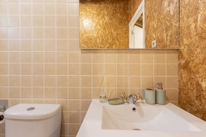 A bathroom with a toilet, sink, and mirror. - Holiday Home 'Casa da Avó Deolinda' with Mountain View in Grijó (Gafanhão)