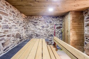 A stone-walled room with a wooden bench and a door. - Holiday Home 'Casa da Avó Deolinda' with Mountain View in Grijó (Gafanhão)