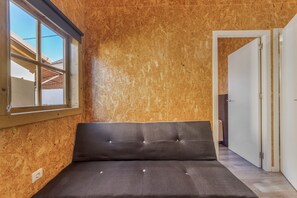 Una stanza con un letto, una finestra e una porta.