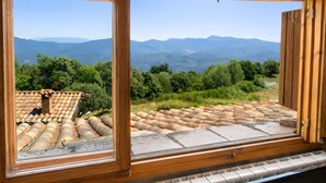 Una habitación con un ventanal que da a un paisaje montañoso.