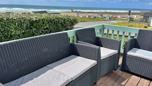 A wicker outdoor seating area with a view of the beach and ocean. - Scenic Haven With Private Pond (Bude)
