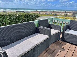 A wicker outdoor seating area with a view of the beach and ocean. - Scenic Haven With Private Pond (Bude)
