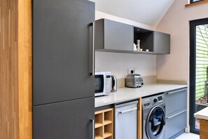 Eine kleine Küche mit Einbauwaschmaschine, Toaster und Kaffeemaschine.
