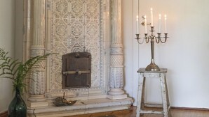 A room with a fireplace, a candelabra, and a patterned rug.