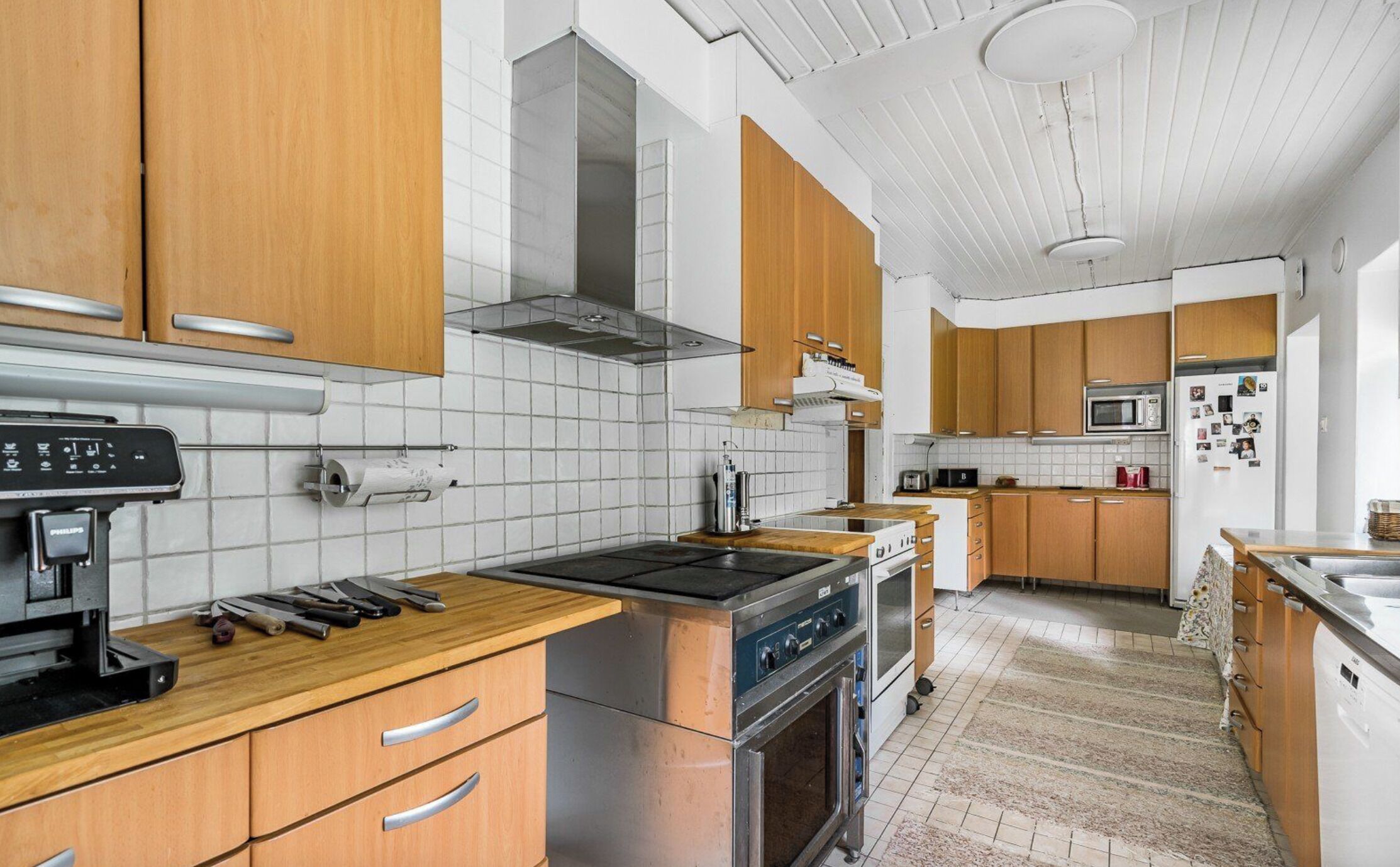 Een moderne keuken met houten kastjes, een roestvrijstalen fornuis en een betegelde spatwand.