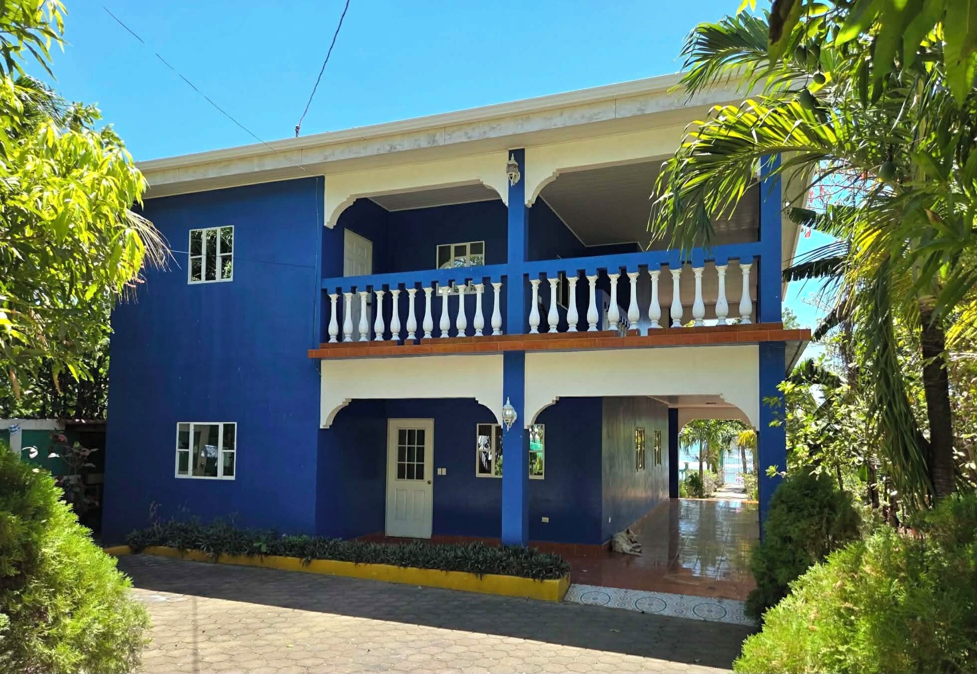 A two-story building with a balcony, a door, and windows.