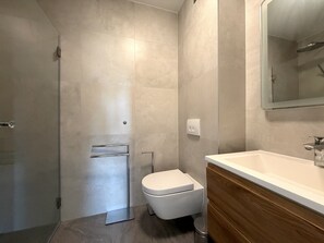 A modern bathroom with a shower, toilet, and vanity. - Two Bedroom Sea View Apartment Marisol (Mrljane)