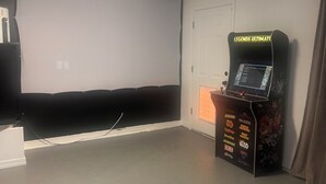 A room with a projector screen, a gaming console, and a door. - Desert Oasis route 66 (Kingman)