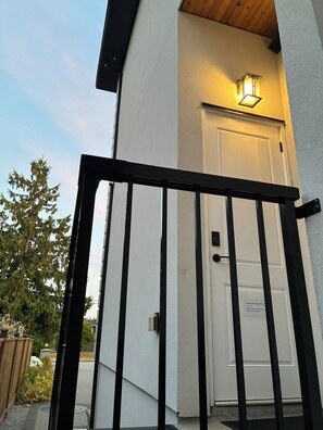 A gated entrance to a building with a white door and a sign indicating shoe and slipper entry.