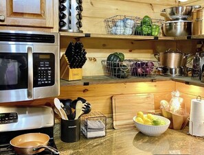 A kitchen with stainless steel appliances, wooden cabinets, and various kitchen utensils and ingredients. - Lakefront retreat: Your Blue Ridge Escape - Pet Friendly (Morganton)