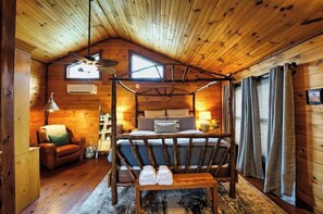 A cozy cabin bedroom with a four-poster bed, a wooden ceiling, and a large window. - Lakefront retreat: Your Blue Ridge Escape - Pet Friendly (Morganton)
