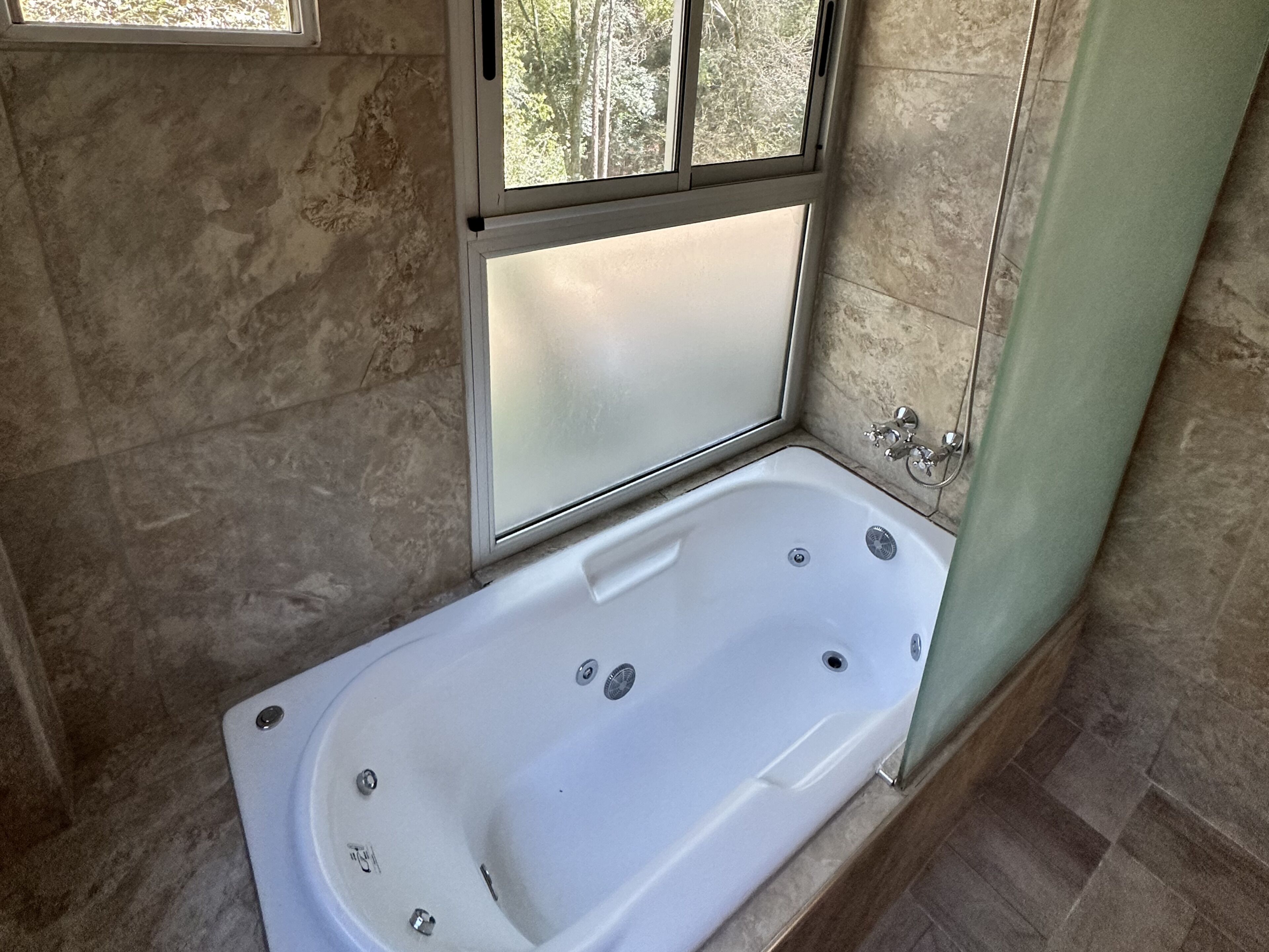 Un baño moderno con una bañera independiente, un ventanal y una zona de ducha.