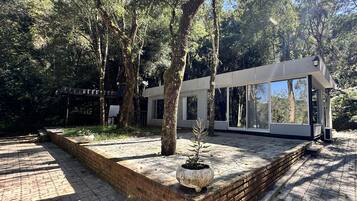 Un edificio moderno con grandes ventanales, rodeado de árboles.