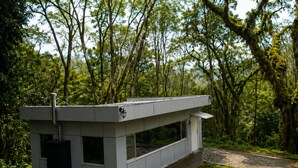 Ein modernes, minimalistisches Gebäude mit flachem Dach, großen Fenstern und einem kleinen Eingang.