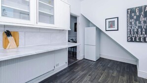 A modern kitchen with white cabinetry, a built-in oven, and a refrigerator. - Stylish 2 Bedroom Home Sleeps 4 (St Helens)