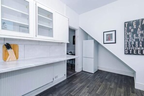 Eine moderne Küche mit weißen Schränken, einem Einbauofen und einem Kühlschrank.