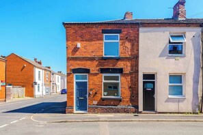 A two-story building with a brick facade and a flat roof. - Stylish 2 Bedroom Home Sleeps 4 (St Helens)