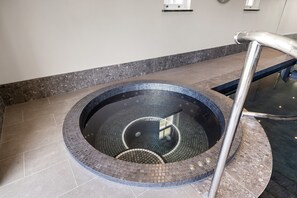 A circular hot tub with a tiled interior and a metal handrail. - Cawsand Waterfront House With Pool (Torpoint)