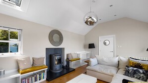 Uma sala de estar moderna com lareira, sofá, mesa de centro e estante.