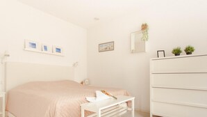 A bedroom with a bed, bedside table, dresser, and wall-mounted mirror. - Villa With Panoramic Water Views (Makkum)