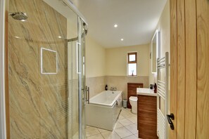 A bathroom with a glass shower enclosure, a bathtub, a toilet, and a sink with a wooden vanity. - Family Cottage Near Wilsthorpe Beach (Driffield)