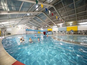 An indoor swimming pool with multiple lanes, a diving board, and colorful flags. - Cosy Cornwall Bungalow for 4 (St Ives)