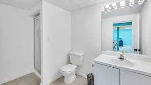 Et moderne badeværelse med toilet, håndvask og spejl.