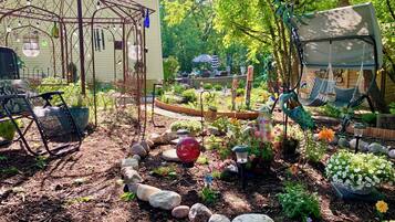 Un jardin agrémenté d’un belvédère, de bancs et d’une grande variété de plantes.