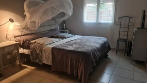 A bedroom with a bed, bedside table, lamp, and a window with blinds. - Villa 'Latour' with Wi-Fi and Air Conditioning (Latour-Bas-Elne)
