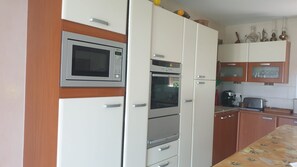 Une cuisine équipée d’un four à micro-ondes, d’un four traditionnel et de placards.