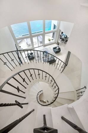 A spiral staircase with a view of a balcony and outdoor seating area. - Breathtaking Oceanfront Luxury Penthouse! (San Miguel de Cozumel)