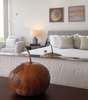 A living room with a sofa, a lamp, and decorative items on the wall. - Breathtaking Oceanfront Luxury Penthouse! (San Miguel de Cozumel)