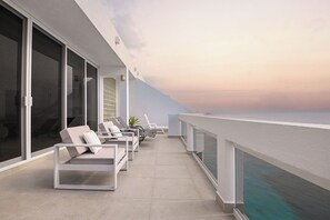 A balcony with sun loungers, a potted plant, and a view of the sea. - Breathtaking Oceanfront Luxury Penthouse! (San Miguel de Cozumel)