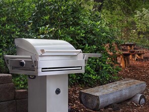 A barbecue grill with a control panel, set against a backdrop of greenery and wooden logs. - 2 Bedroom Villa at Marriott OceanWatch Resort (Myrtle Beach)