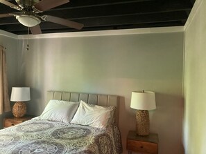 A bedroom with a bed, two bedside lamps, a ceiling fan, and a nightstand. - Spacious 6BR Pocono Retreat / 5 Min to Lake Wallenpaupack./ Sleeps 12 / 3 pools (Lake Ariel)