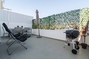 A rooftop terrace with a seating area, a grill, and a decorative fence. - 'Graça' Apartment with Private Terrace (Lisbon)