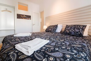 A hotel room with a bed, two pillows, a nightstand, and a wall-mounted lamp. - 'Graça' Apartment with Private Terrace (Lisbon)