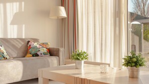 A modern living room with a sofa, a coffee table, and a potted plant. - Detached Waterfront Villa With Garden (Makkum)