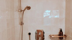 A bathroom with a shower, a towel rack, and a bottle of shampoo. - Weald Base for Four Guests (Tenterden)