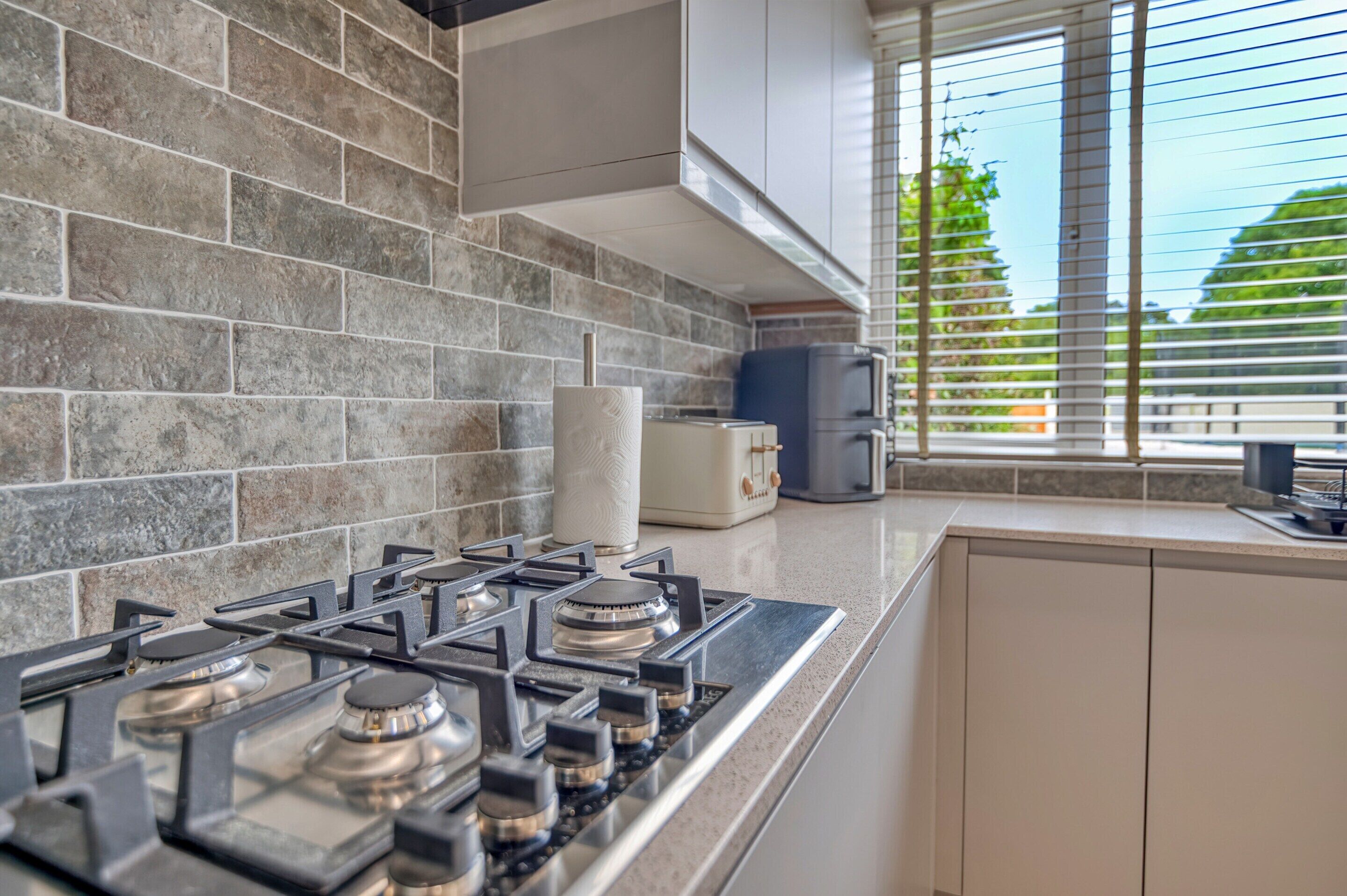 A kitchen with a gas stove, a toaster, and a coffee maker.