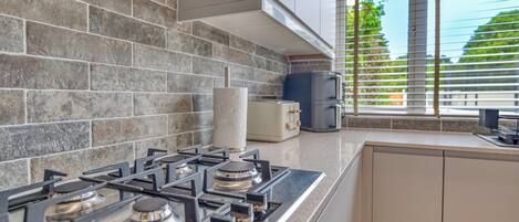 A kitchen with a gas stove, a toaster, and a coffee maker.