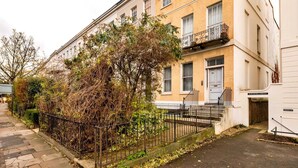 A two-story building with a flat entrance and a visible door number. - Elegant Apartment in Regency Cheltenham (Cheltenham)