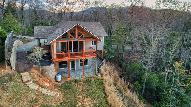 A two-story house with a balcony, surrounded by trees and a hilly landscape. - Sunset Views (Blairsville)