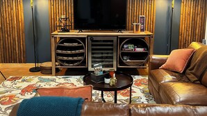 A living room with a flat-screen TV, leather sofa, and a patterned rug. - Sunset Views (Blairsville)
