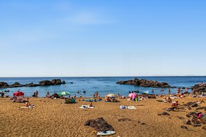 A beach with people sunbathing, swimming, and playing. - Holiday Apartment 'Casa Sherazad' with Sea View, Private Terrace and Wi-Fi (Tías)